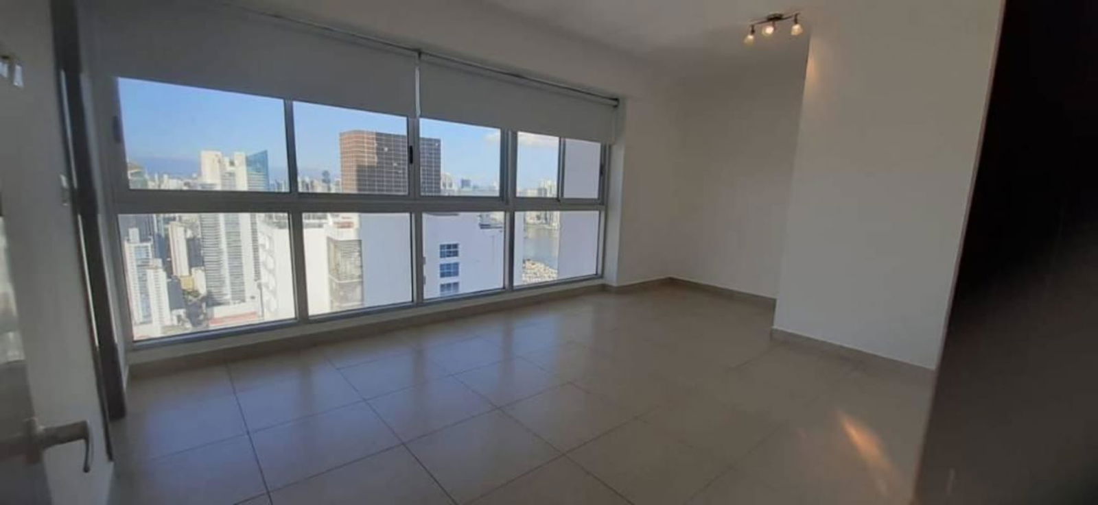 Empty spacious bedroom with large windows offering skyline panorama at Rivage Tower Panama City