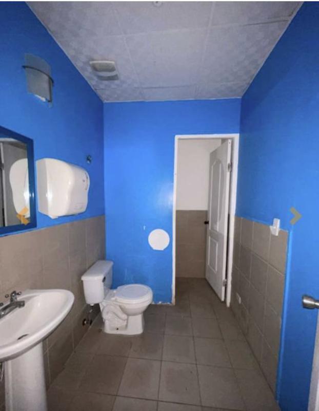 Simple blue beige commercial bathroom with sink toilet mirror tile Brisas del Golf Panama