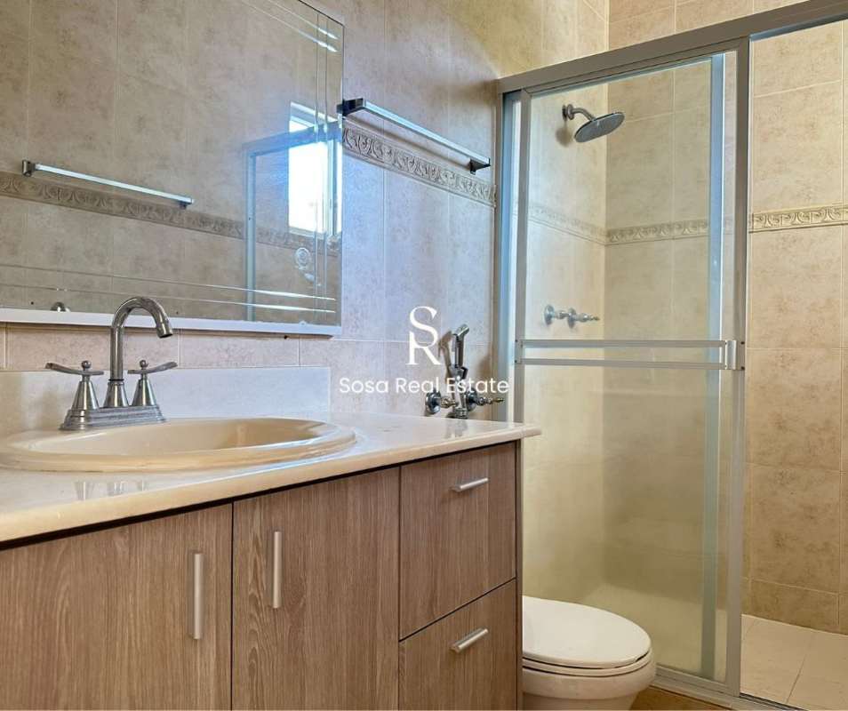 Modern ensuite bathroom with glass shower and beige tiles Costa del Este rented home