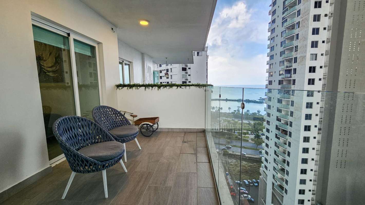 Modern living room with blue accent sofa, dining table and large window PH Green View 43 Panama