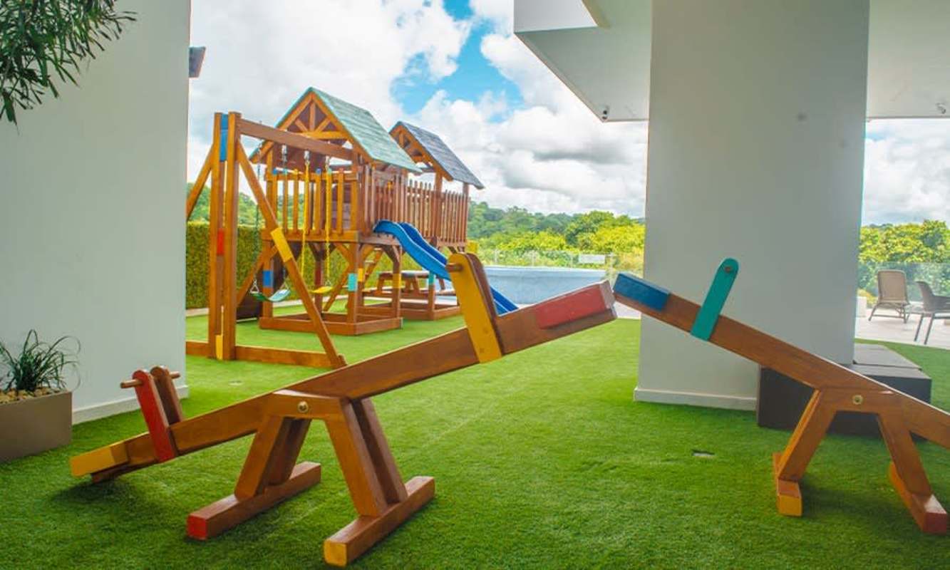 Children's playground with slide seesaw green artificial grass Edison Park Panama
