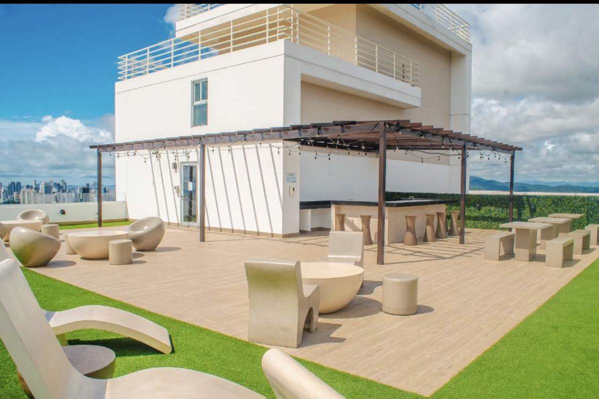 Modern infinity swimming pool with lounge chairs in Edison Park Panama City