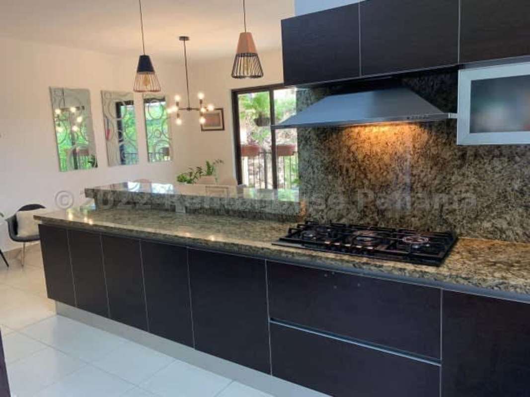 Kitchen with granite countertop, built-in oven, breakfast bar in Clayton Panama apartment