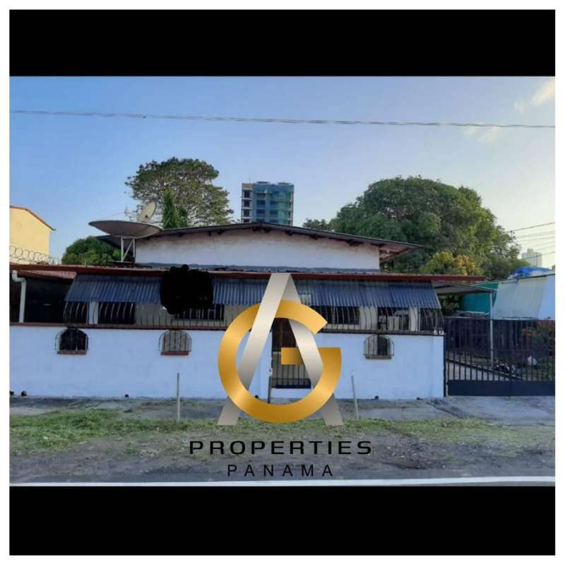 Street-level view of property fence with entrance gate and adjoining buildings Parque Lefevre Panama
