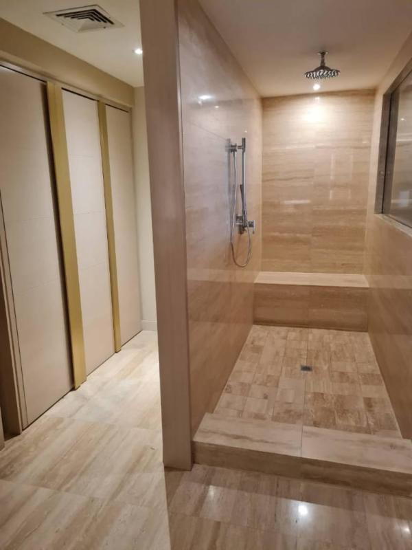 Luxury walk-in shower bathroom with marble tiles and bench in Panamera Residences Panama