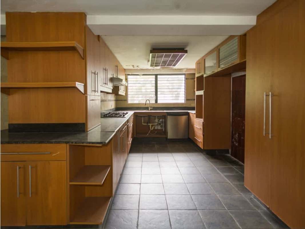Spacious kitchen with wooden cabinetry, granite countertops Coco del Mar foreclosed house Panama