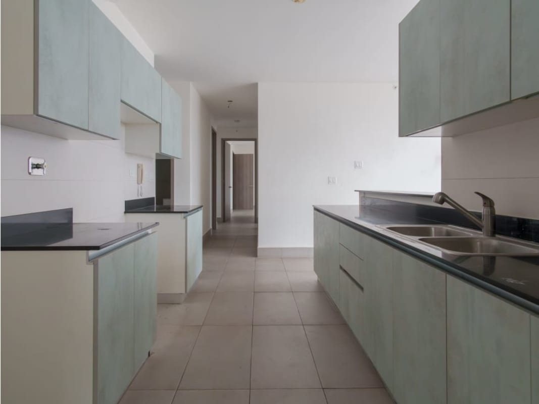 Modern minimalist kitchen with mint green cabinetry and black countertops at PH Loma Vista Tower Panama.