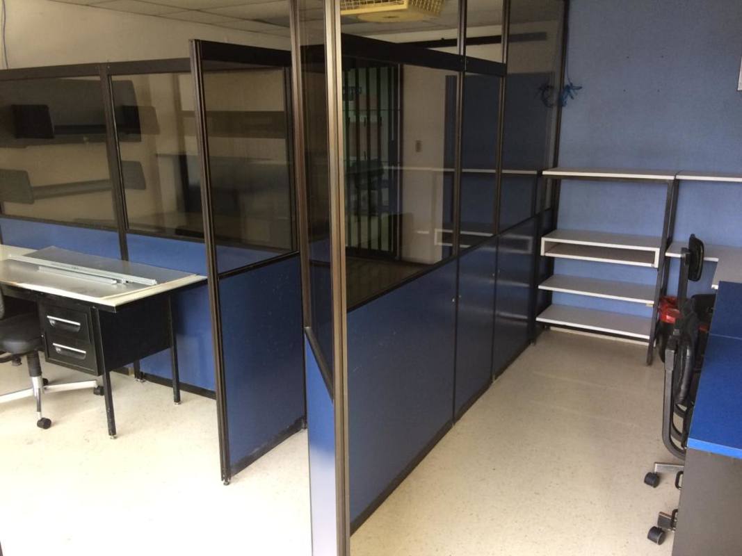 Small interior office setup with blue/black cubicles and glass partitions in El Dorado Panama