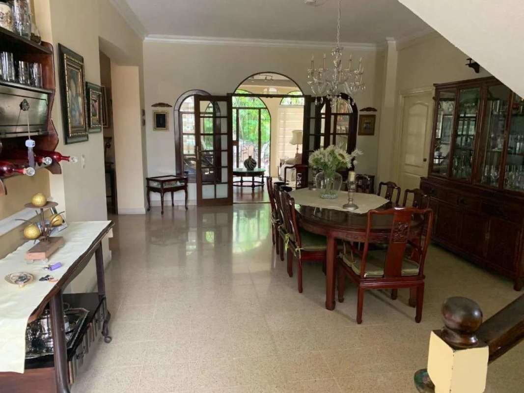 Dining room with wood dining table, chandelier, garden views Villa de Las Fuentes Panama