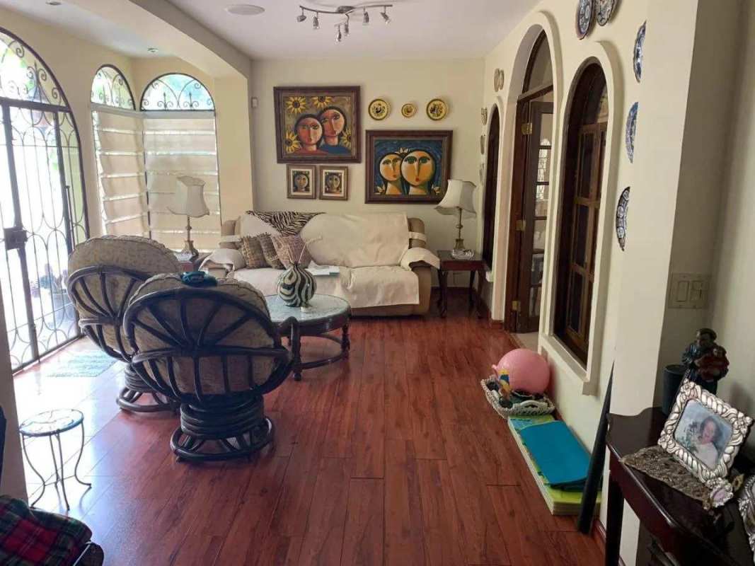 Spacious living area with arched windows, white sofa, rattan chairs Villa de Las Fuentes Panama