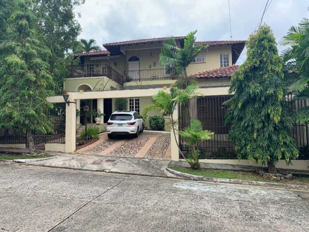 Mediterranean two-story house with red tile roof, balcony and lush green Villa de Las Fuentes Panama