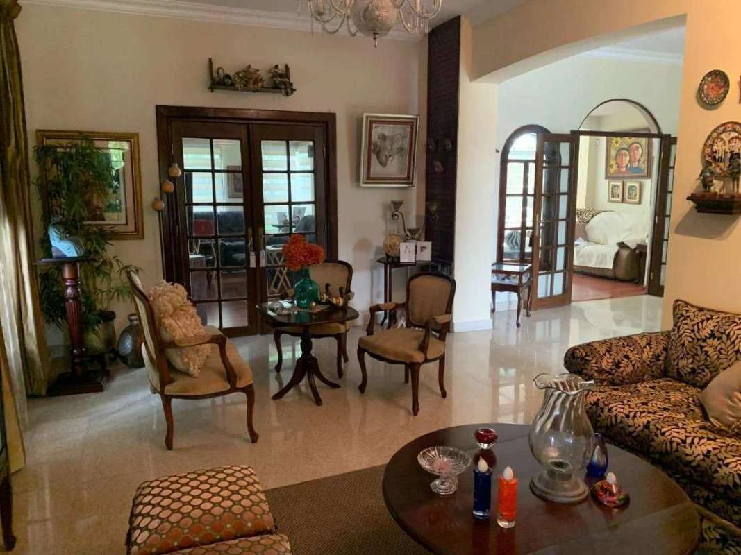 Spacious traditional living room with glass door access and classic furnishings Villa de Las Fuentes Panama