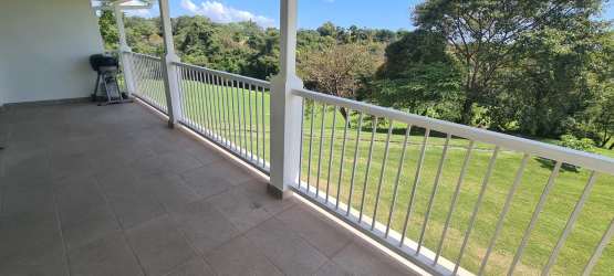 Granite kitchen with breakfast bar open to living dining area at Bijao Golf Resort Panama