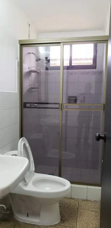 Minimalist bathroom with pedestal sink, mirror with frame and glass shower enclosure