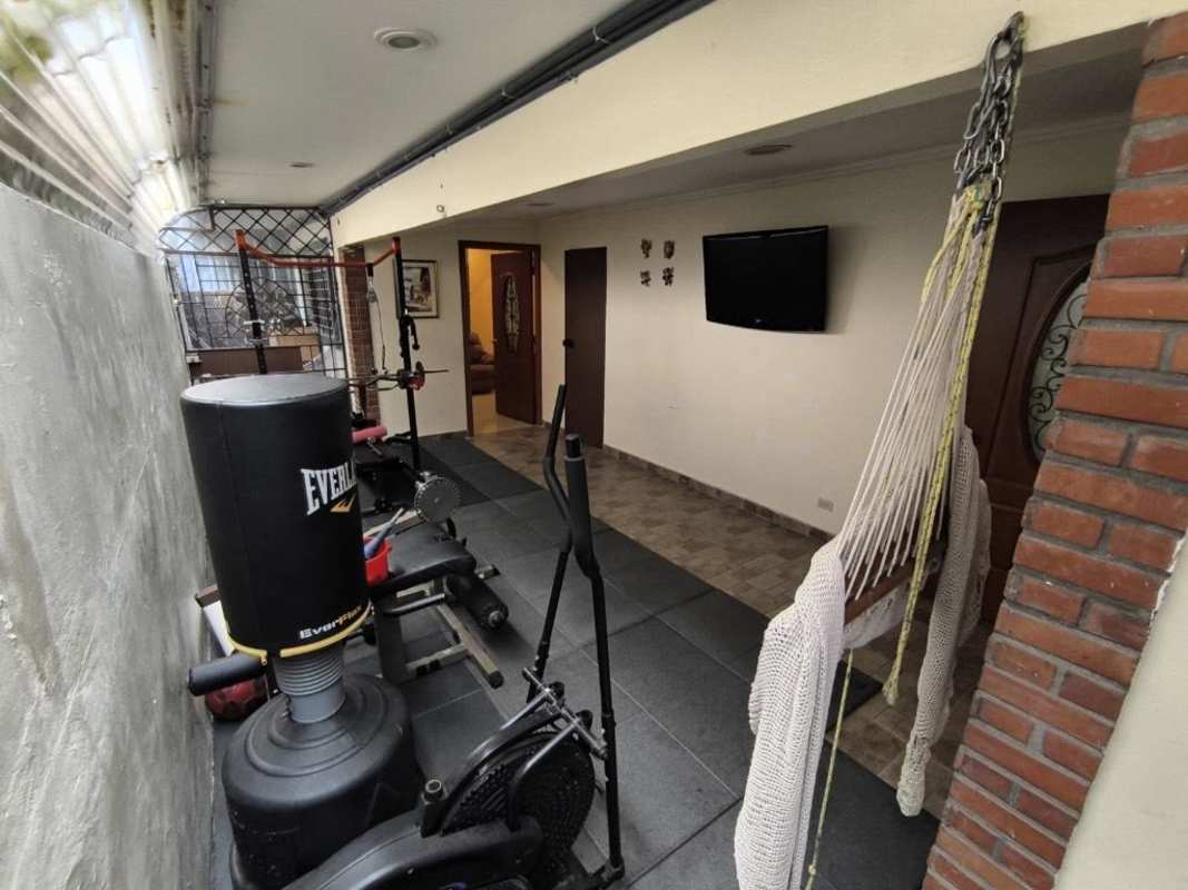 Indoor gym space with workout setup and hammock chair at single family Chanis Panama home