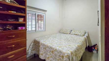 Simple bedroom with window, bed and closet in beach house Panama