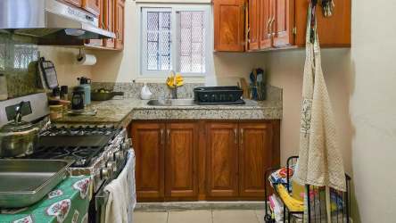 Kitchen with granite countertop, stove, and wooden cabinets in beach house Panama