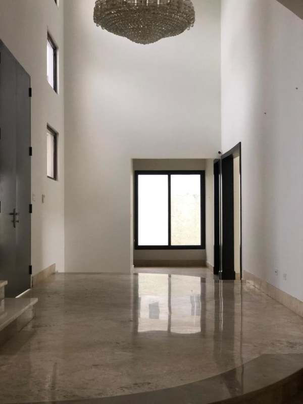 Spacious entryway with marble flooring, chandelier, tall double doors in luxury Costa del Este house Panama