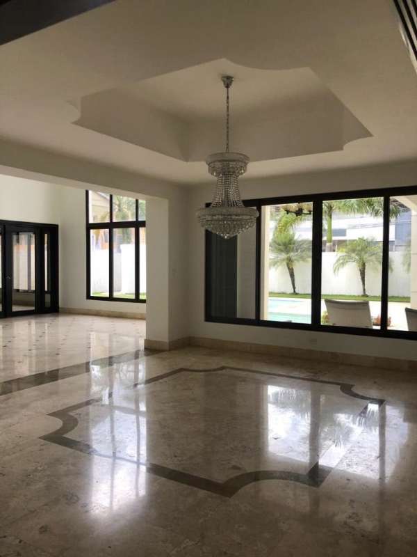 Large living area with decorative ceiling, marble floors and picture windows in Costa del Este house Panama