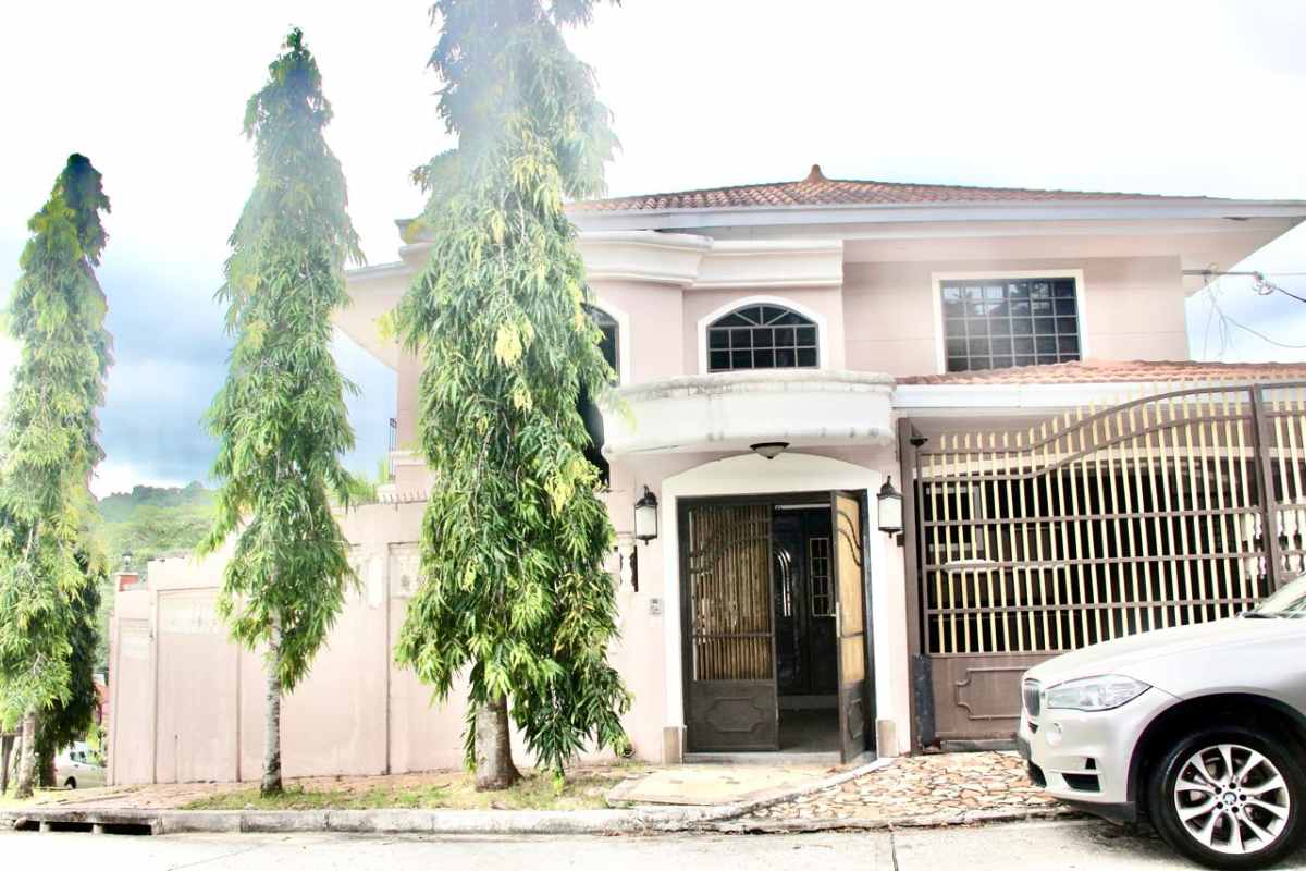 Living room with brick accent wall and large windows in Villa de las Fuentes house Panama