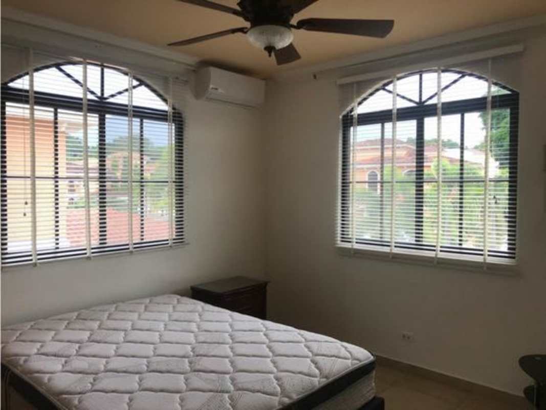 Bedroom with large window, ceiling fan, AC, and neutral tones Clayton Village Panama