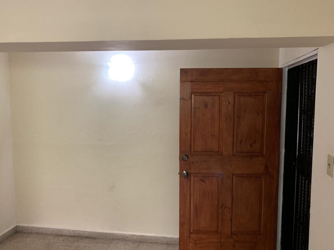 Entryway with solid wooden door and security gate in La Loceria ground floor apartment Panama