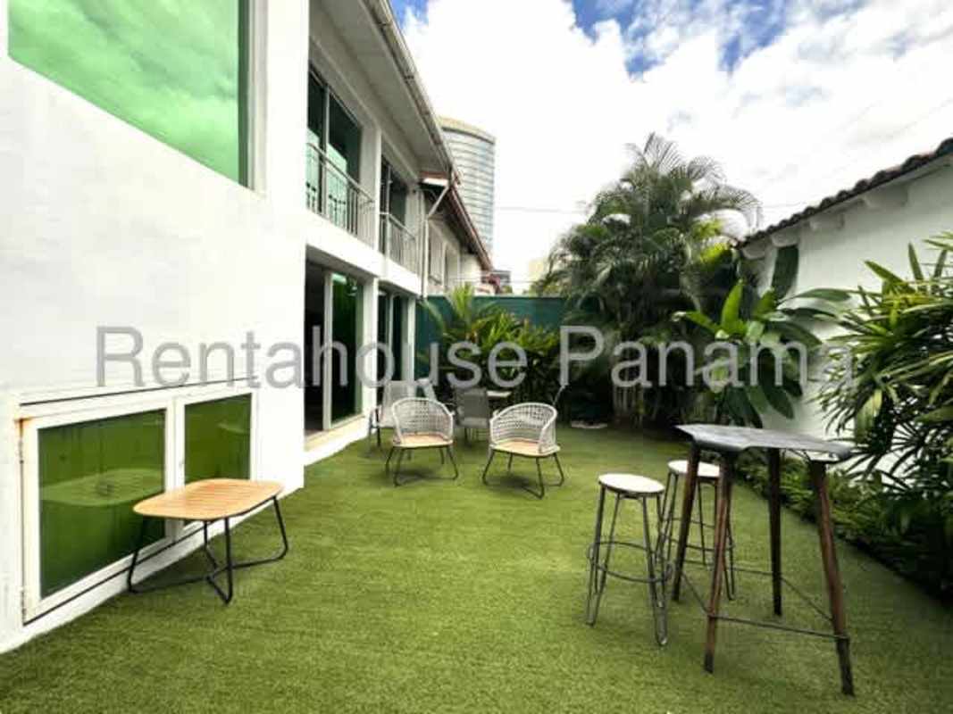 Swimming pool area with deck and blue chairs La Alameda Betania Panama City