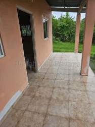 Covered tiled patio area and lawn in countryside house San José Panama