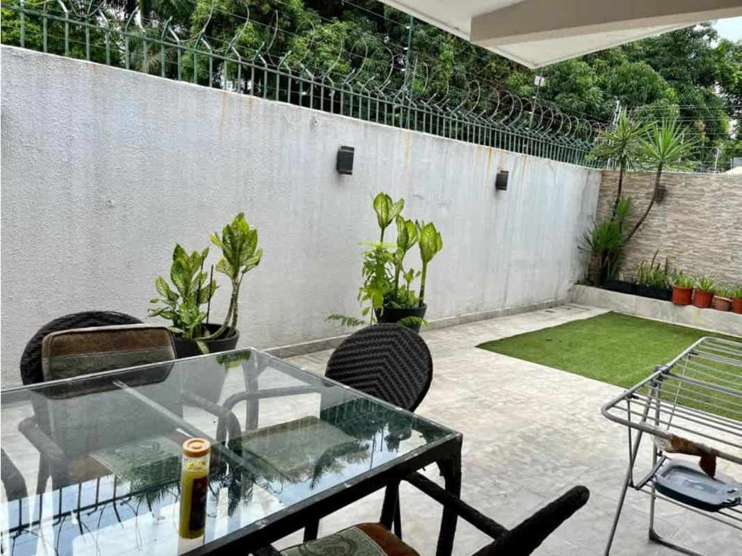 Outdoor patio courtyard with table, plants, and garden wall in Altos del Golf home