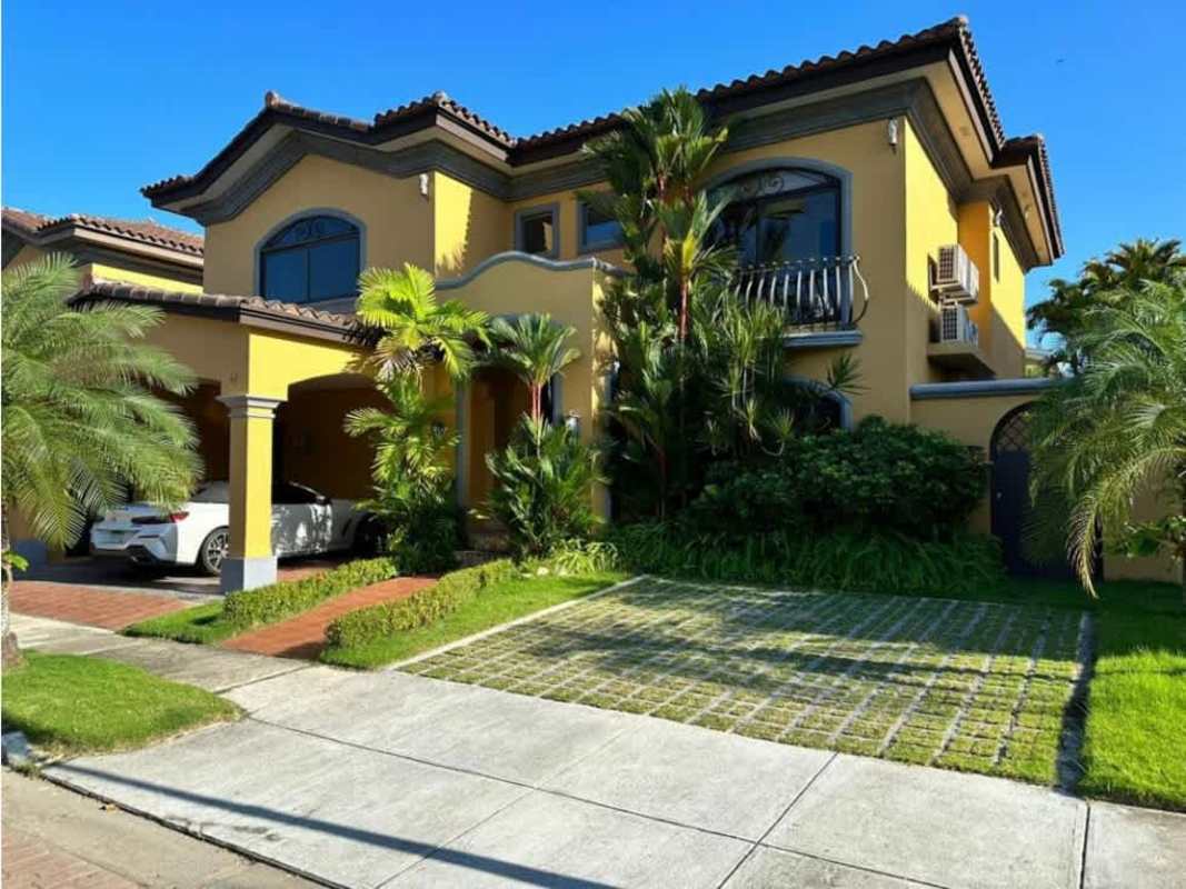 Two-story Mediterranean style house with tile roof and tropical landscaping in Costa del Este