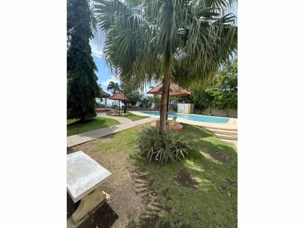 Outdoor pool area with gazebos and palm trees in gated community Betania Panama