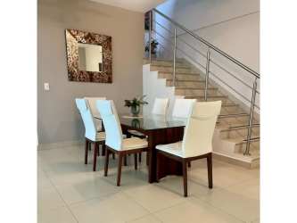 Modern dining room with glass table next to staircase in River Valley Panama Pacifico