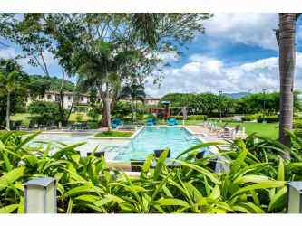 Swimming pools with lounge chairs, palm trees Panama Pacifico townhouse community