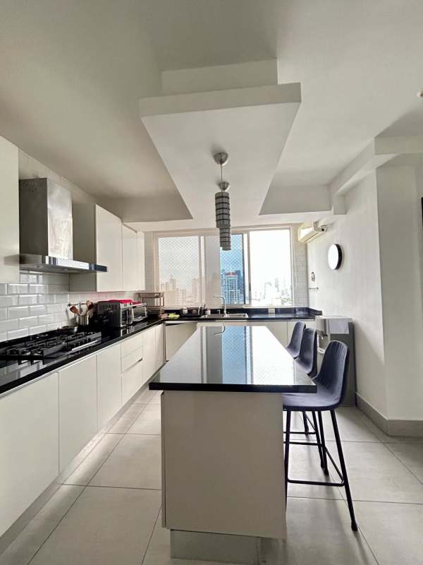 Living room with sliding glass doors to balcony, gray flooring, modern lighting in PH Jade Tower Panama City