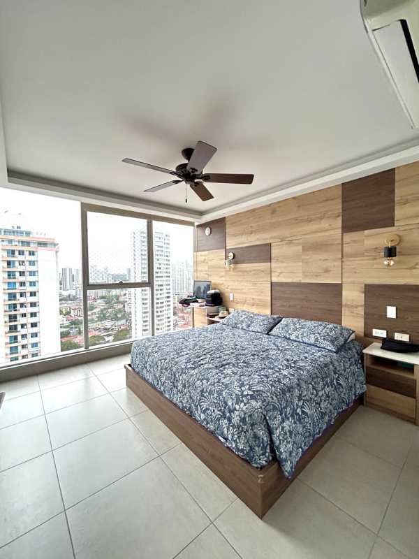Master bedroom with wood accent wall, large windows, blue bedding, ceiling fan PH Jade San Francisco Panama