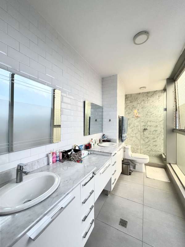 Bathroom with double sinks, marble counter, glass shower, large window in PH Jade Tower Panama
