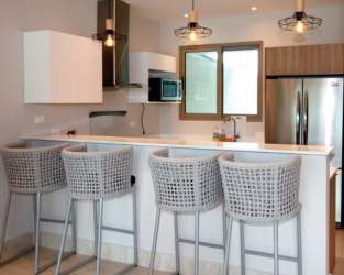 Contemporary kitchen with quartz counters and breakfast bar in Caribbean resort apartment Playa Escondida Colón