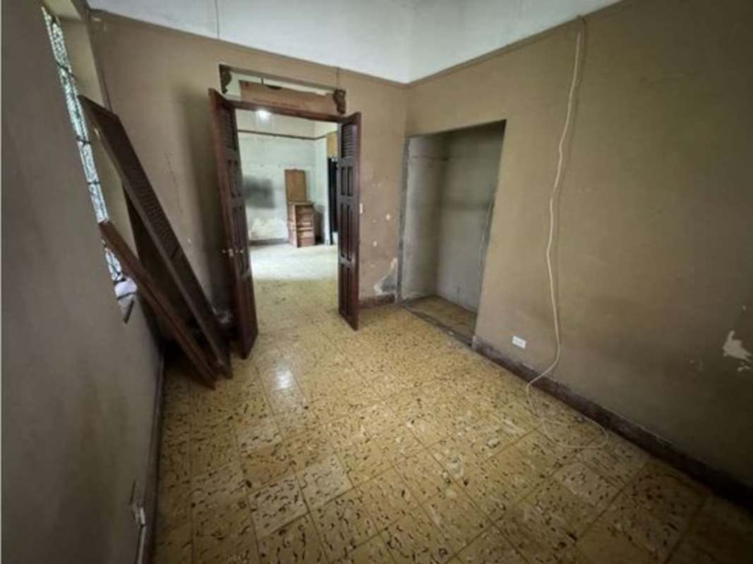 Spacious bedroom with barred windows and natural light in corner Panama City home for rent