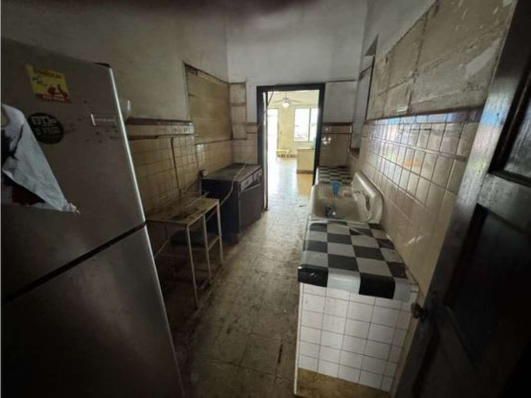 Vintage style kitchen with tiled walls, black and white countertop in Avenida Balboa home for rent Panama