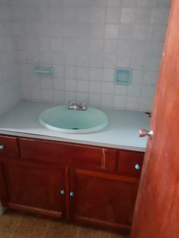 Bathroom vanity with blue sink, wood cabinet and tiled backsplash at PH 12 de Octubre Panama