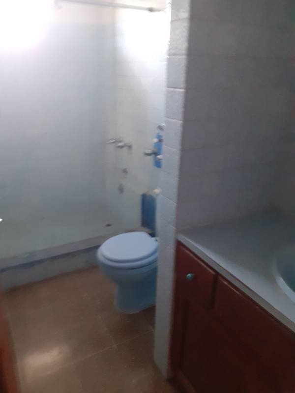Traditional bathroom toilet and shower area with blue accents at PH 12 de Octubre apartment Panama
