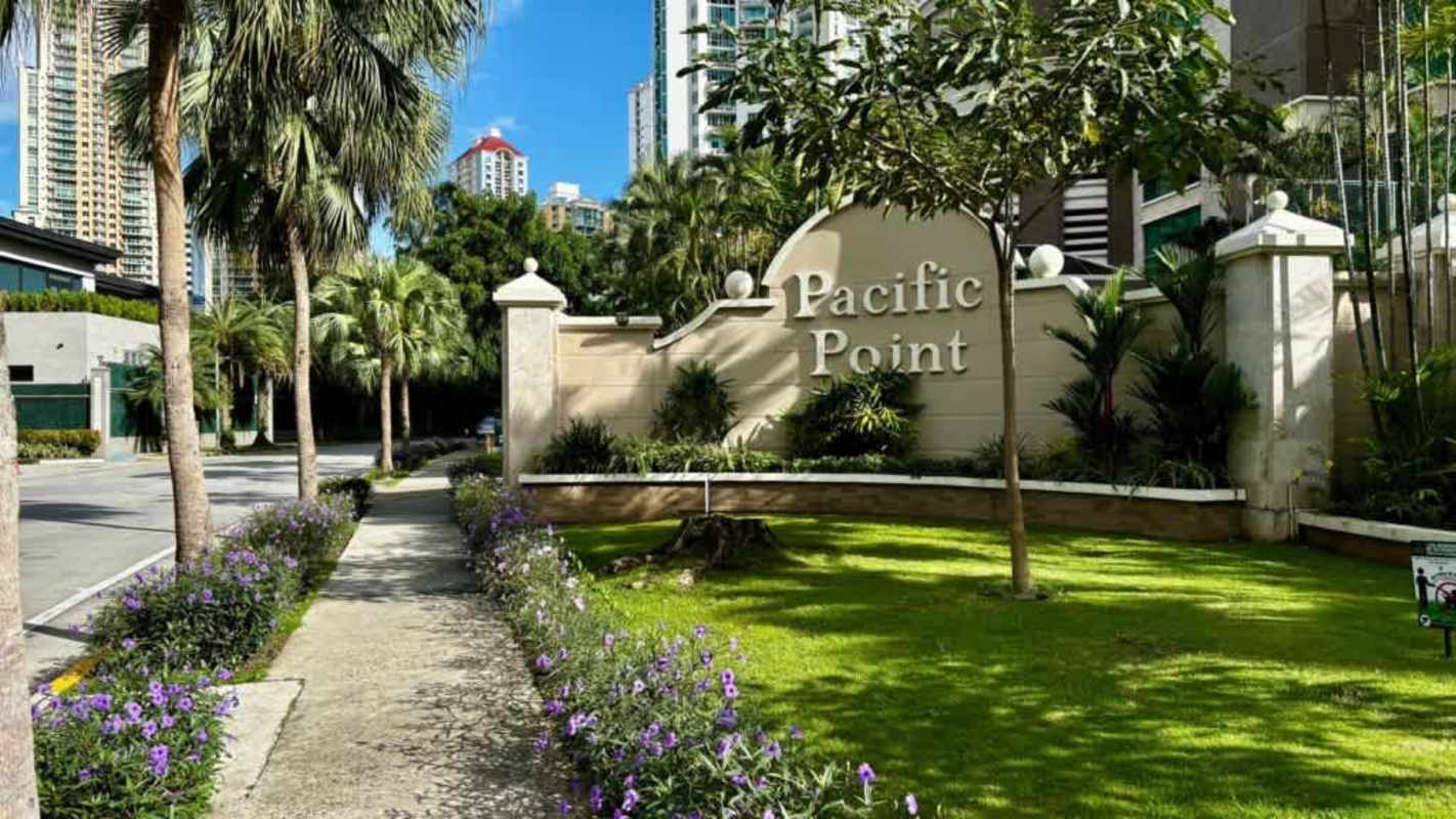 Spacious red-walled bedroom with city view windows wood floor Pacific Point Punta Pacifica