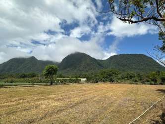Wide grassy lot with mountain backdrop under clear blue sky in El Valle Panama