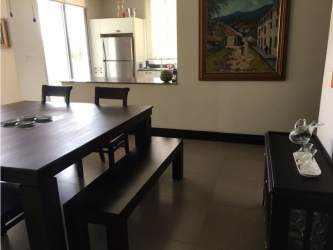 Furnished dining area with open kitchen and ocean view balcony at PH Rio Mar San Carlos Panama