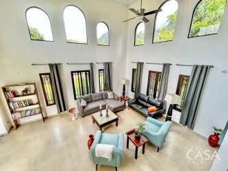 Spacious living room with arched windows, double-height ceilings, contemporary Mediterranean decor in El Valle Panama