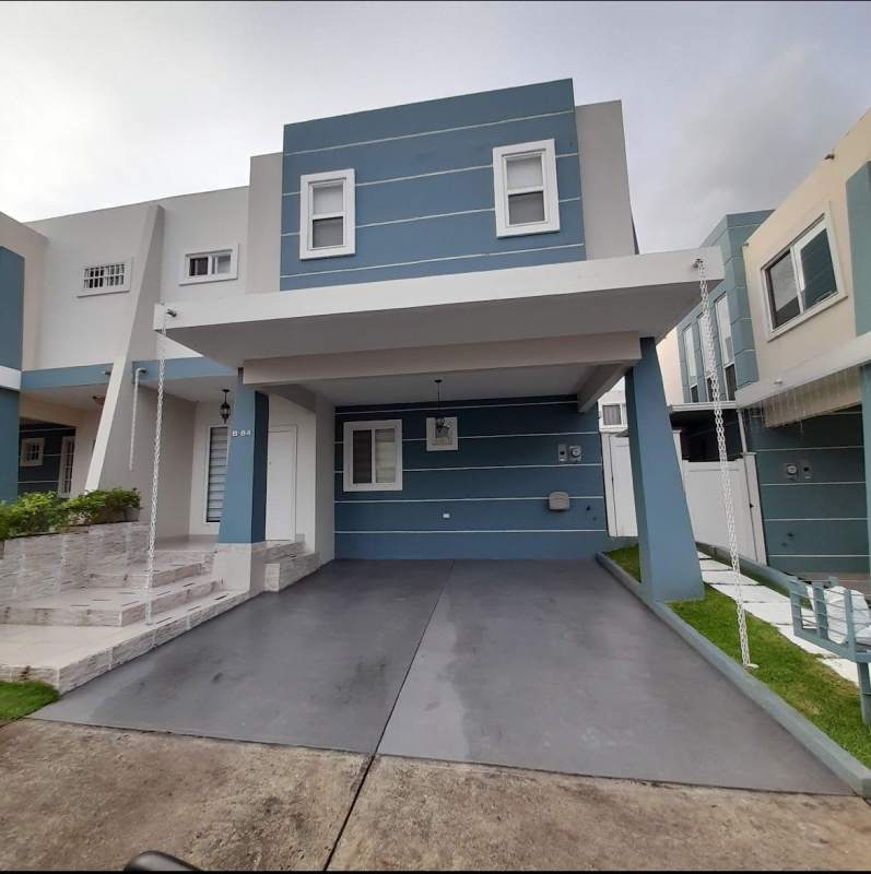 Townhouse facade with blue and white exterior, covered carport, landscaped steps in Brisas del Golf Panama