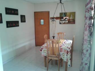 Living room with ceiling fan, brown sofas, tiled floor in house for sale Chitré Panama