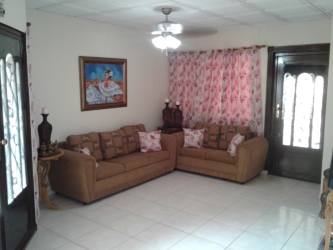 Dining room with wooden furniture, floral curtains in house for sale Chitré Panama