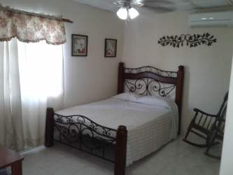 Traditional bedroom with bed, AC, ceiling fan furnished home for sale Chitré Panama