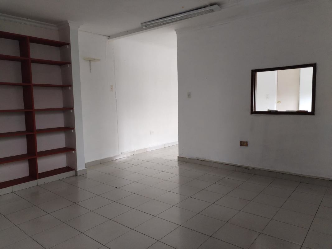 Office room with built-in shelves and pass-through window in Villa Cáceres